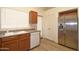Well lit kitchen featuring wood cabinets, stainless steel fridge, dishwasher, sink, and vinyl plank flooring at 2667 S 156Th Ave, Goodyear, AZ 85338