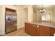Open concept kitchen featuring wooden cabinets, a stainless steel refrigerator, and vinyl flooring at 2667 S 156Th Ave, Goodyear, AZ 85338