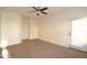 Living room featuring carpet floors, a ceiling fan, and an exterior door at 2667 S 156Th Ave, Goodyear, AZ 85338