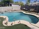 Backyard pool featuring an artificial grass surround, stone coping, and patio seating at 277 W 16Th Ave, Apache Junction, AZ 85120