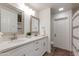 Bright bathroom featuring double sinks, quartz countertop, framed mirrors, and white cabinets at 3020 E Mission Ln, Phoenix, AZ 85028