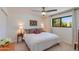 Bright bedroom with a ceiling fan, carpet floors, and a window with a view to the outside at 3020 E Mission Ln, Phoenix, AZ 85028