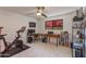 This bedroom features a ceiling fan, a large window, and contains workout equipment and office furniture at 3020 E Mission Ln, Phoenix, AZ 85028