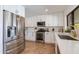 A modern kitchen featuring white cabinets, stainless steel appliances, and a sink with a golden faucet at 3020 E Mission Ln, Phoenix, AZ 85028