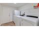 Clean laundry room with washer, dryer, refrigerator, shelving, and door to outside at 3020 E Mission Ln, Phoenix, AZ 85028