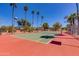 Tennis court on property with palm trees, lights, and mountain views at 3020 E Mission Ln, Phoenix, AZ 85028
