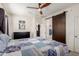 Bright bedroom featuring a ceiling fan, wood sliding door, and ensuite access at 3231 S Mingus Dr, Chandler, AZ 85286