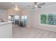 Open-concept living room with luxury vinyl flooring, large windows, and modern ceiling fan at 3236 E Chandler Blvd # 3031, Phoenix, AZ 85048