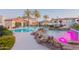 Resort-style pool with pink waterfall feature, lounge chairs and clubhouse in the background at 3236 E Chandler Blvd # 3031, Phoenix, AZ 85048