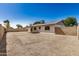 Wide-angle view of the backyard featuring gravel landscaping, a wall, and a covered patio at 4121 W Paradise Dr, Phoenix, AZ 85029