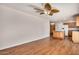 Open living room and kitchen with wood-look floors and ceiling fan at 4121 W Paradise Dr, Phoenix, AZ 85029