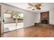 Inviting living room featuring a brick fireplace, wood floors, and sliding glass doors to the backyard at 4121 W Paradise Dr, Phoenix, AZ 85029