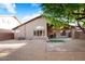 Backyard with desert landscaping, a small patch of artificial turf, and mature trees at 418 E Clairidge Dr, San Tan Valley, AZ 85143