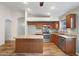 Kitchen features an island with a breakfast bar and stainless-steel appliances and tile floors at 418 E Clairidge Dr, San Tan Valley, AZ 85143