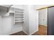 Walk-in closet with white built-in shelves and closet rods, with access to bathroom at 418 E Clairidge Dr, San Tan Valley, AZ 85143