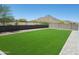 A fully enclosed backyard features artificial turf and mountain views at 4215 W Suncup Dr, San Tan Valley, AZ 85144