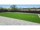 Large backyard features artificial turf, a block wall, and a paved patio area, perfect for outdoor entertaining at 4215 W Suncup Dr, San Tan Valley, AZ 85144
