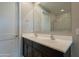 Bathroom with double sinks, dark cabinets, and a shower with glass doors at 4215 W Suncup Dr, San Tan Valley, AZ 85144