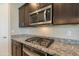 Close up on gourmet style kitchen including granite countertops, stainless steel microwave and gas cooktop at 4215 W Suncup Dr, San Tan Valley, AZ 85144