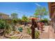 Beautifully landscaped backyard featuring lush greenery, decorative elements, and a peaceful patio area at 44041 W Bailey Dr, Maricopa, AZ 85138