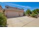 Home featuring a three-car garage, large driveway, and desert landscaping at 44041 W Bailey Dr, Maricopa, AZ 85138