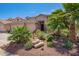 Landscaped front yard featuring gravel, rock features, and vibrant desert plants at 44041 W Bailey Dr, Maricopa, AZ 85138