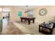 The game room features a pool table, neutral walls, and views into other living spaces at 44041 W Bailey Dr, Maricopa, AZ 85138