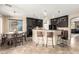 A modern kitchen featuring dark cabinets, stainless appliances, and a breakfast bar at 44041 W Bailey Dr, Maricopa, AZ 85138