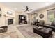 Living room with a fireplace, ceiling fan, plush seating, and a large decorative area rug at 44041 W Bailey Dr, Maricopa, AZ 85138