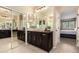 Bathroom with beautiful dark wood cabinetry, large mirrors, and tile floors at 44041 W Bailey Dr, Maricopa, AZ 85138