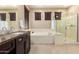 Bright bathroom featuring a glass shower, soaker tub, and granite countertops at 44041 W Bailey Dr, Maricopa, AZ 85138