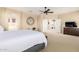 Bright and spacious main bedroom with a large bed, a ceiling fan and ensuite bathroom access at 44041 W Bailey Dr, Maricopa, AZ 85138