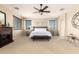 Spacious bedroom featuring a ceiling fan, fireplace, and serene neutral decor at 44041 W Bailey Dr, Maricopa, AZ 85138