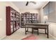Spacious home office with plenty of natural light and custom bookcases at 44041 W Bailey Dr, Maricopa, AZ 85138
