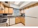 Well-lit kitchen featuring bright wood cabinets, neutral countertop and flooring, and white appliances at 4531 W Continental Dr, Glendale, AZ 85308