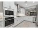 Modern kitchen features stainless steel appliances, pristine white cabinetry, and quartz countertops at 506 E Balao Dr, Phoenix, AZ 85085