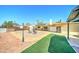 A spacious backyard featuring a built in bbq, stone tile, artificial turf, and a wood patio at 5347 W Seldon Ln, Glendale, AZ 85302
