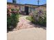 Charming single-story home with a brick walkway surrounded by colorful, blooming bushes and mature plantings at 5347 W Seldon Ln, Glendale, AZ 85302