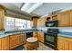 Functional kitchen with light wood cabinets, sleek black appliances, and durable countertops at 5347 W Seldon Ln, Glendale, AZ 85302