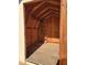 Interior view of the shed featuring a wooden floor, exposed rafters, and a small shelf at 5347 W Seldon Ln, Glendale, AZ 85302