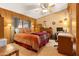 Cozy bedroom with wood-paneled walls, a ceiling fan, and a comfortable bed at 535 S Alma School Rd # 85, Mesa, AZ 85210