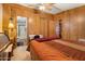 Bedroom featuring wood-paneled walls and a door leading to the attached bathroom at 535 S Alma School Rd # 85, Mesa, AZ 85210