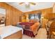 Bedroom featuring wood-paneled walls, a ceiling fan, and a comfortable bed at 535 S Alma School Rd # 85, Mesa, AZ 85210