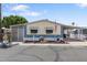 Charming home exterior with manicured landscaping, covered carport, and an American flag at 535 S Alma School Rd # 85, Mesa, AZ 85210