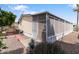 Home exterior featuring low-maintenance landscaping, a screened-in porch, and a small patio at 535 S Alma School Rd # 85, Mesa, AZ 85210