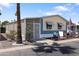 Charming manufactured home featuring a well-maintained yard, covered entry, and classic American flag at 535 S Alma School Rd # 85, Mesa, AZ 85210
