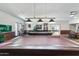 Game room features billiard tables with pendant lighting and views through an arched opening to a dining area at 535 S Alma School Rd # 85, Mesa, AZ 85210