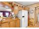 Charming kitchen featuring wooden cabinets, a white refrigerator, and a cozy, inviting atmosphere at 535 S Alma School Rd # 85, Mesa, AZ 85210