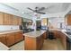 Spacious kitchen with wood cabinets, large island, stainless steel appliances, and tile flooring at 535 S Alma School Rd # 85, Mesa, AZ 85210