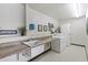 Clean laundry room with ample counter space, sink, stacked washer and dryer, and neutral decor at 535 S Alma School Rd # 85, Mesa, AZ 85210